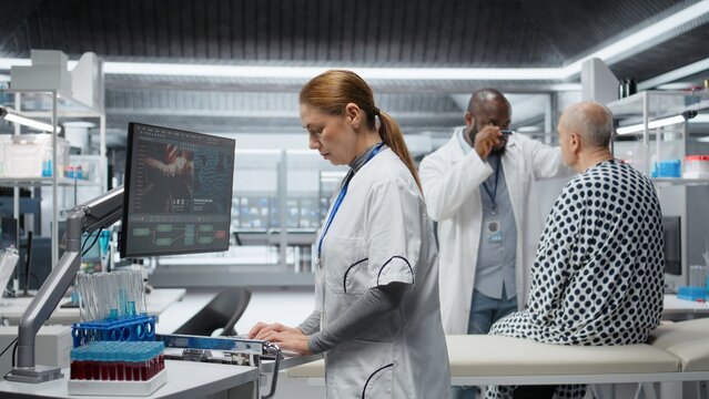 Nurse records clinical trial data during a drug study with a patient, documenting reactions and dosage effects contributing to product development and pharmacology research. Camera A.