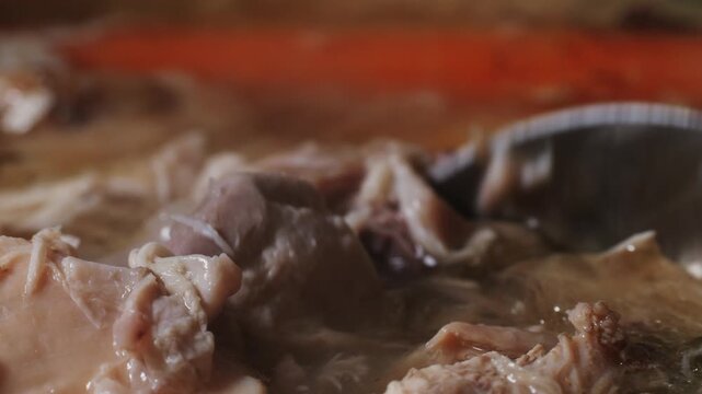 Cooking pot with bone broth meat pork and beef, aspic north food. Vegetables cooking ingredients and spices on kitchen table. 