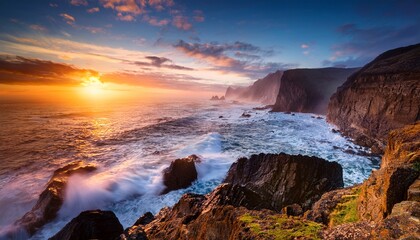 Obraz premium Dramatic Sunset Over Rocky Coastline And Misty Ocean