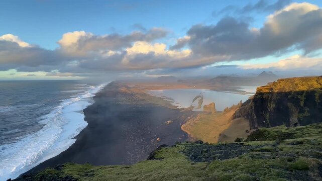 Wide static panoramic view of black sand beach and coastal lagoon at sunset, Dyrholaey, Iceland. HD 1080p.