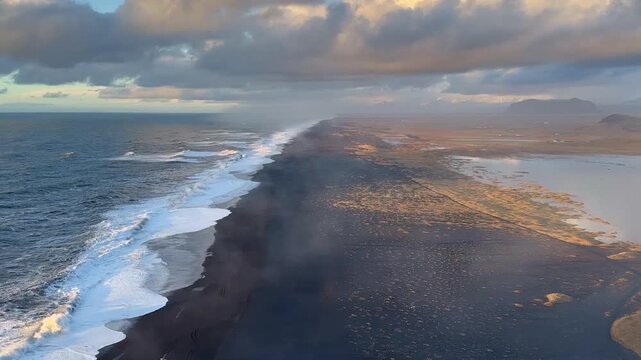 Static wide shot of endless black sand coastline and ocean waves at sunset, Dyrholaey, Iceland. HD 1080p.