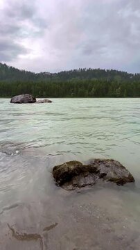 The turquoise mountain river Katun flows through the mountains with rocky islands. Altai Republic, Russia. The water flow. The slopes of the mountain ranges in the valley are covered with forests.4К
