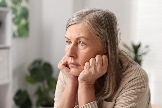 Amnesia. Senior woman trying to remember something at home