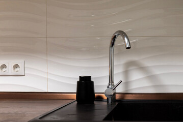 Chrome faucet black soap dispenser on kitchen sink