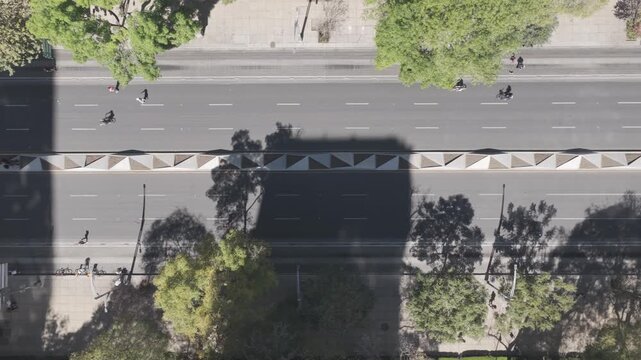 Aerial drone flying sideways top down over Ciclot&oacute;n Dominical in Paseo de la Reforma with cyclists and runners in M&eacute;xico City. Shot in D-Log M 