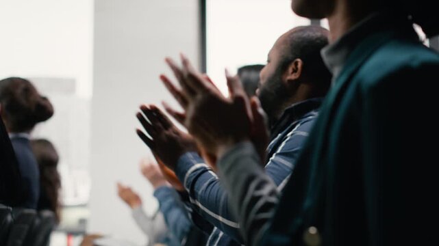 Diverse group audience applauding and greeting speaker during discussion. Multiethnic white collar workers and executives attend international event, meeting in conference hall. Camera B.