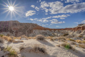 Fototapeta premium A desert landscape with a sun shining brightly in the sky