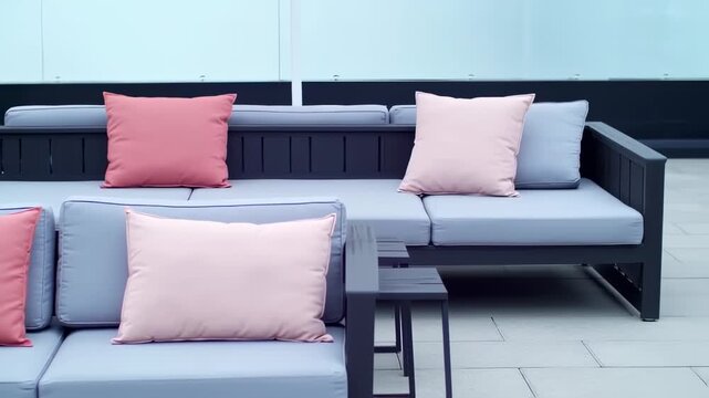 Dark gray outdoor sectional sofa with pink and light gray cushions