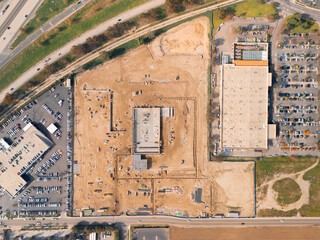 Aerial view of a large-scale construction site with heavy machinery and industrial building progress.ult
