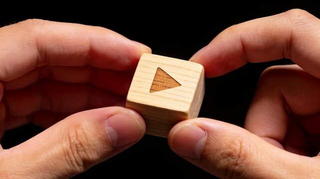 再生ボタン付き木製ブロックを指先で持つミニマルデザイン