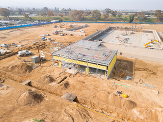 Aerial view of a large-scale construction site with heavy machinery and industrial building progress.ult