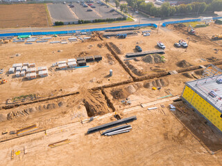 Aerial view of a large-scale construction site with heavy machinery and industrial building progress.ult