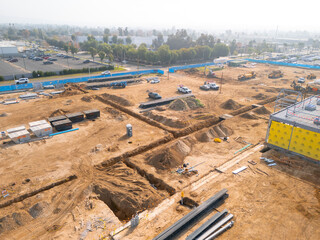 Aerial view of a large-scale construction site with heavy machinery and industrial building progress.ult