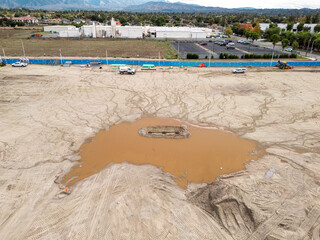 Aerial view of a large-scale construction site with heavy machinery and industrial building progress.ult
