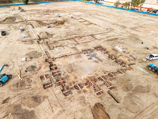 Aerial view of a large-scale construction site with heavy machinery and industrial building progress.ult