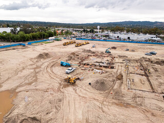 Aerial view of a large-scale construction site with heavy machinery and industrial building progress.ult