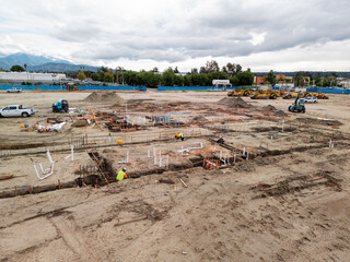 Aerial view of a large-scale construction site with heavy machinery and industrial building progress.ult