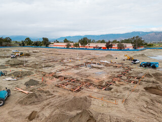 Aerial view of a large-scale construction site with heavy machinery and industrial building progress.ult