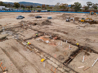 Aerial view of a large-scale construction site with heavy machinery and industrial building progress.ult