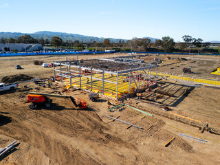 Aerial view of a large-scale construction site with heavy machinery and industrial building progress.ult
