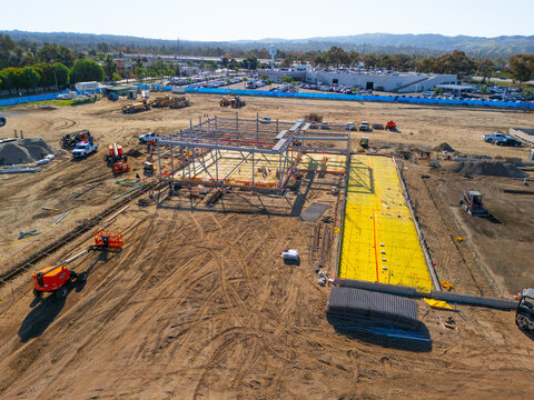 Aerial view of a large-scale construction site with heavy machinery and industrial building progress.ult