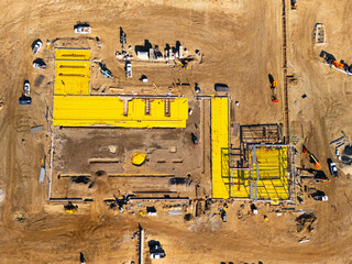 Aerial view of a large-scale construction site with heavy machinery and industrial building progress.ult