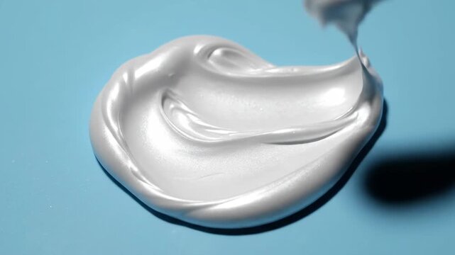 Glossy White Slime Swirling on a Light Blue Surface with Sparkles and Soft Lighting