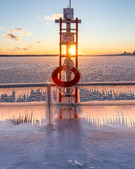 Naklejka premium Icicles forming on a rail at a frozen pier at sunset - Polson Pier, Toronto Ontario