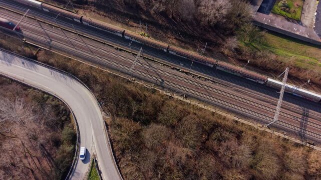Railway and Road in Harmony: Aerial view of a winding road juxtaposed with a parallel railway track, symbolizing the dynamic interplay of transport and travel. 