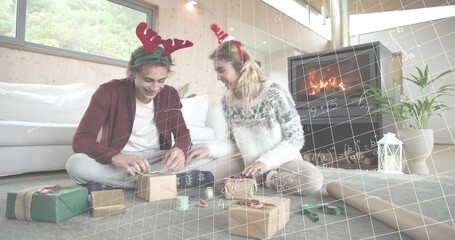 Obraz premium Wrapping friends wearing festive headbands and knits on living room floor, with gifts and ribbon