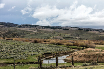 Naklejka premium Mountain Valley with Stream and Sagebrush Hills