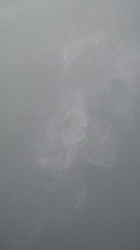 Monochromatic Dust Veil An extreme close-up on a matte, desaturated surface where fine grain particles behave like a subtle dust veil. This 'veil' slowly shifts, accumulates, and disperses in a