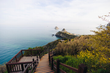 Obraz premium Oryukdo Islands landscape, Busan, South Korea, with Skywalk observation deck and Deungdaeseom island Lighthouse, Busan Bay, Yongho-dong, Nam District, coastal walk, Igidae Park trail, sunny spring day