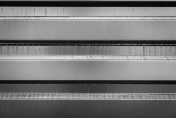 Corrugated metal fencing in black and white with dirt streaks