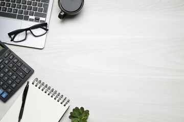 Obraz premium Office workplace. Laptop, coffee and stationery on white wooden desk, flat lay. Space for text