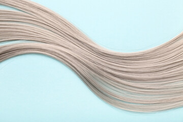 Grey hair strand on blue background