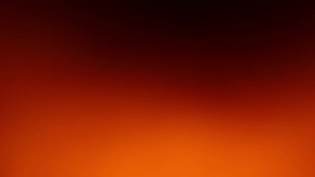 Una toma de cerca de un fondo abstracto de color rojo o anaranjado con negro un degradado ligero desenfocado en movimiento