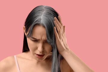Fototapeta premium Young woman with graying hair on pink background, closeup
