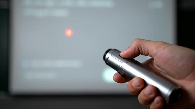 Hand Holding Silver Remote Control Device.