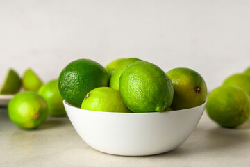 Bowl with fresh ripe limes on grunge table