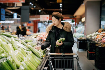Woman Shopping for Fresh Cucumbers in Supermarket