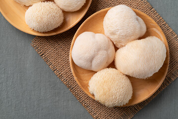 Top view of fresh Lion's Mane mushroom on wooden plate,(Hericium erinaceus), known for nootropic benefits and medicinal properties © nungning20