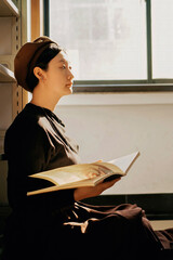 Young woman reading book in vintage styled interior
