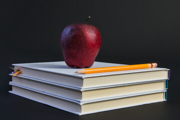 Red apple on stack of white books with yellow pencil for education concept