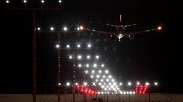 Stockholm, Sweden A plane lands at night in winter on a runway at Arlanda Airport.