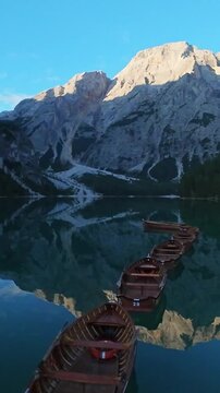 Vertical Screen, Lago Di Braies, Italy Row Of Wooden Boats Near Dock, Rustic Oars, Numbered Hulls, Mountain Reflection, Calming Teal Water, Local Boathouse Owner Polishing Gear, Soft Morning