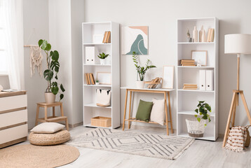 Interior of light room with bookshelves, table and lamp