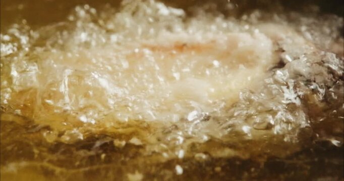油で揚げるクローズアップ　魚の唐揚げ・天ぷら　和食・日本料理　泡立つ油のスローモーション　