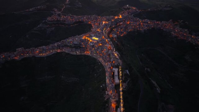 Centuripe glowing star shaped Sicilian mountain town aerial view over the summit at night