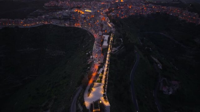 Centuripe illuminated mountain ridge properties aerial night view rising over the star shaped town
